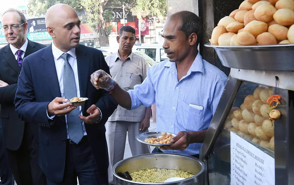 Sajid Javid, United Kingdoms Secretary of State for Business, Innovation and Skills relishing golgappa at a stall at Bengali Market in New Delhi.