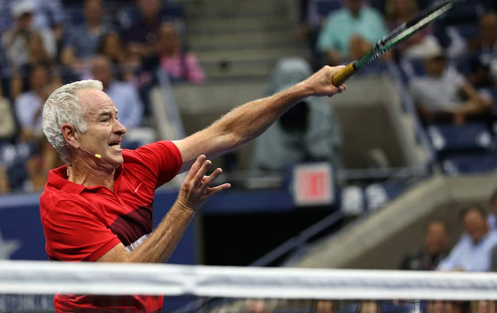 John McEnroe returns a shot as he and Michael Change play Jim Courier and Mardy Fish during an exhibition doubles match at the U.S. Open tennis tournament.