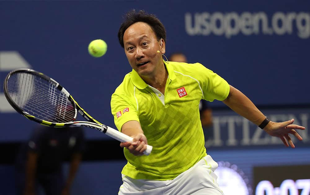 Michael Chang returns a shot to Jim Courier and Mardy Fish during an exhibition doubles match, with Chang teaming with John McEnroe, at the U.S. Open tennis tournament.