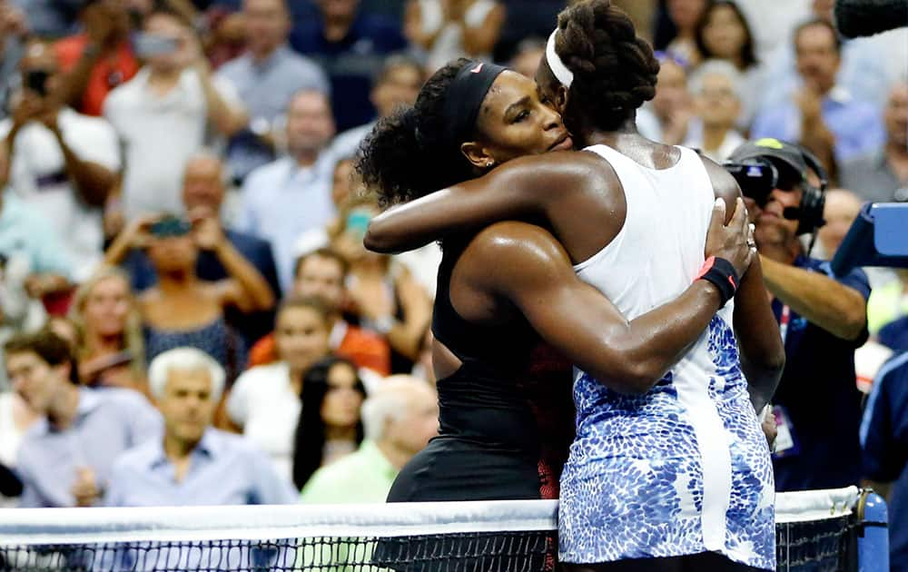 Serena Williams hugs Venus Williams after winning their quarterfinal match at the U.S. Open tennis tournament.