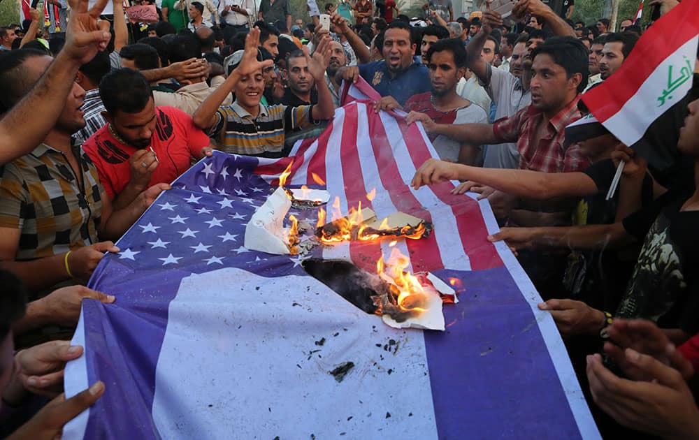 Protesters burn US and Israeli flags during a demonstration against corruption in Basra, 340 miles (550 kilometers) southeast of Baghdad, Iraq.