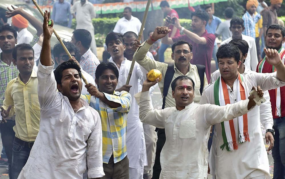 Youth Congress workers celebrate outside party president Sonia Gandhis residence in New Delhi on Saturday for forcing the Narendra Modi government to backtrack on the controversial land bill.