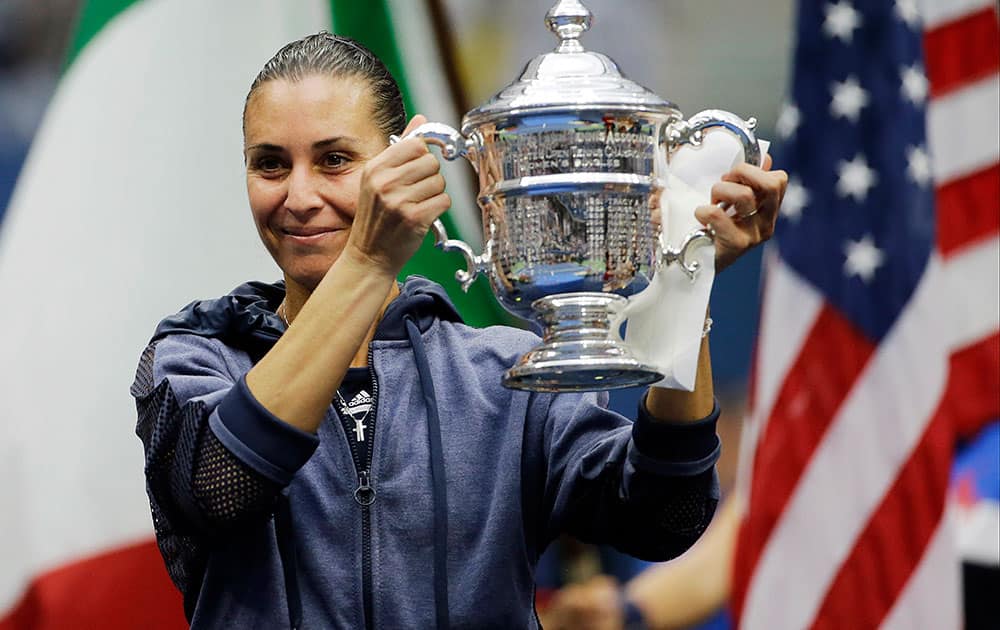 Flavia Pennetta, of Italy, holds up the championship trophy after beating Roberta Vinci, of Italy, in the women's championship match of the U.S. Open tennis tournament.