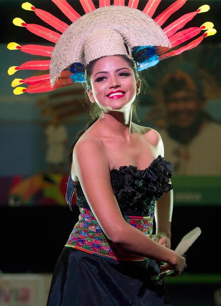 A model wields a fake, wooden machete as she wears a creation by designer from Beni state during the opening ceremony of Bolivia's first Amazon Fair in La Paz, Bolivia.