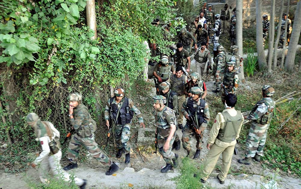 Army personnel rush towards the house where militant was hiding during an encounter,at Pulwama in Srinagar.
