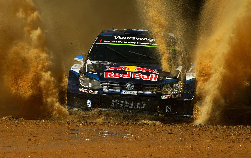 France's Sebastien Ogier races through water on a stage of Rally Australia near Coffs Harbour.