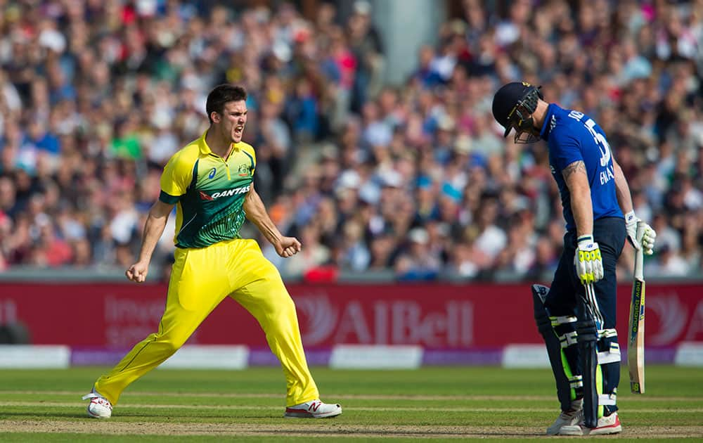 Australia's Mitchell Marsh, left, celebrates after taking the wicket of England's Ben Stokes, right, lbw for 42 during the deciding cricket match of the One Day International series between England and Australia at Old Trafford cricket ground in Manchester, England.