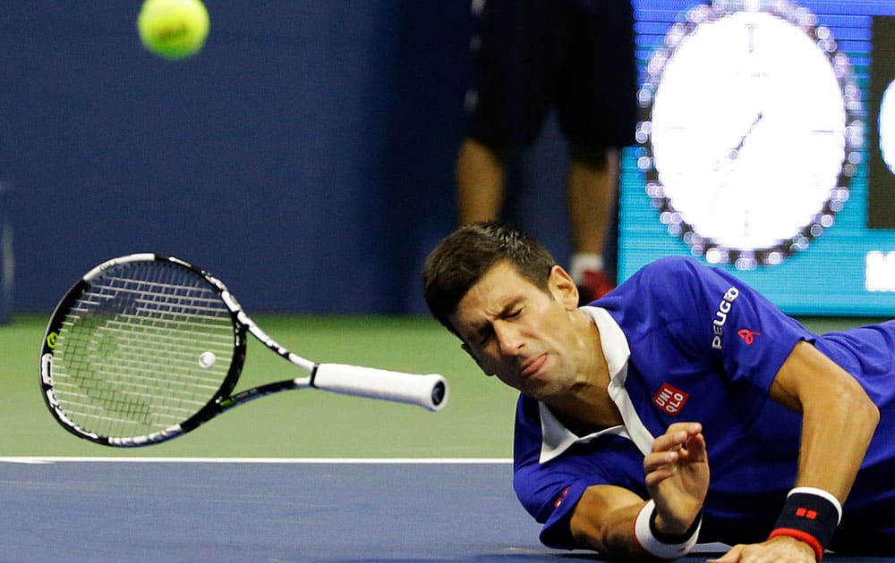 Novak Djokovic, of Serbia, falls to the court while trying to return a shot to Roger Federer, of Switzerland, during the men's championship match of the U.S. Open tennis tournament.