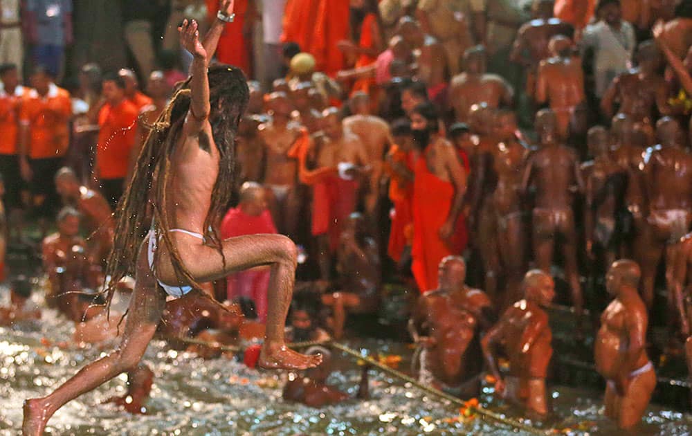 a Naga sadhu, or naked Hindu holy man, jumps in the Godavari River during Kumbh Mela, or Pitcher Festival, at Trimbakeshwar in Nasik, India. 