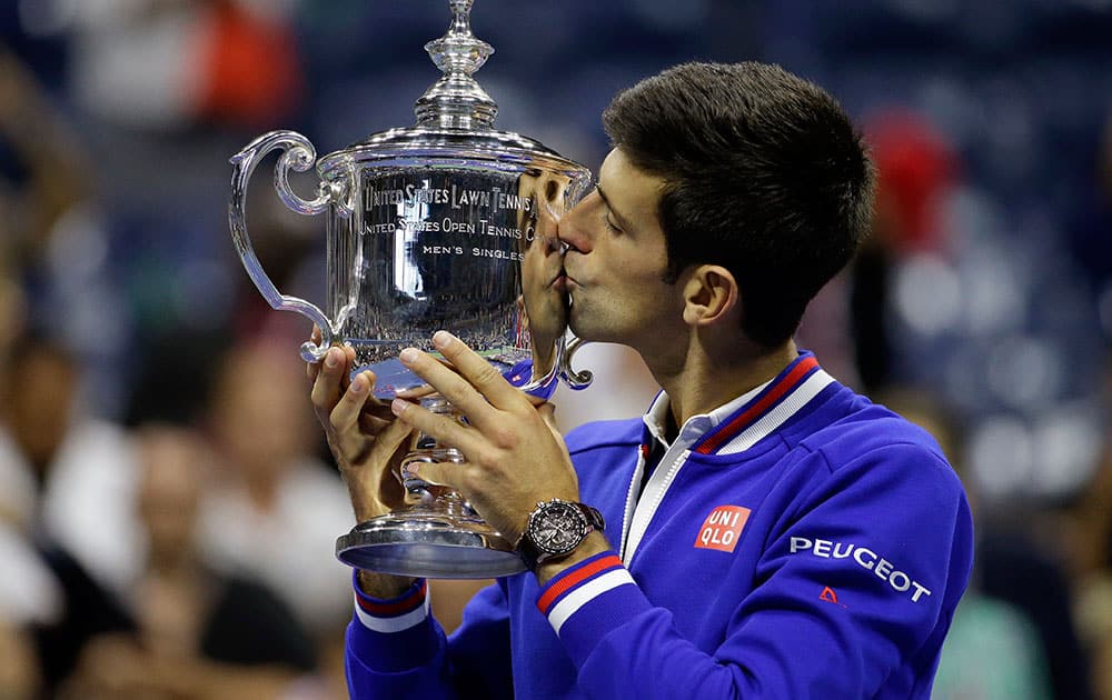 Novak Djokovic, of Serbia, kisses the championship trophy after defeating Roger Federer, of Switzerland, during the men's championship match of the U.S. Open tennis tournament in New York.