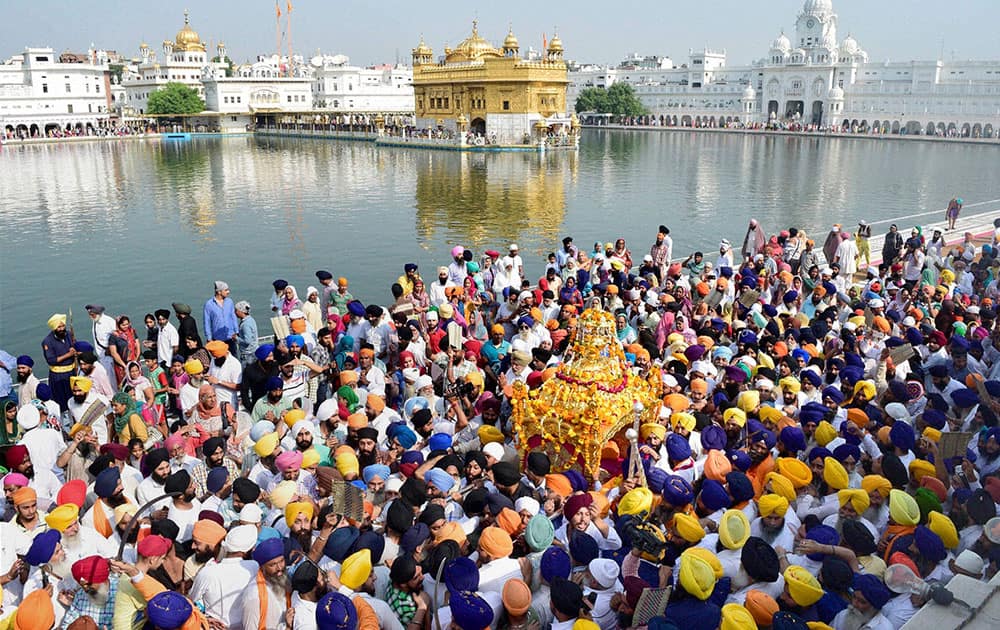 Sikh devotees taking part in a religious procession at Golden Temple in Amritsar on the Occasion of 411th anniversary of Installation of Sri Guru Granth Sahib. 