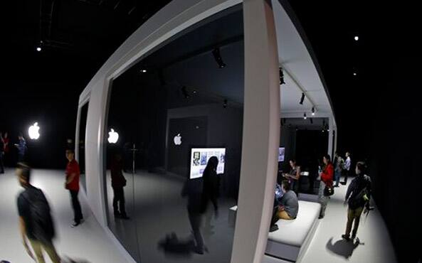 People walk through booths to experience the new Apple TV system during a product display following an Apple event, September 9, 2015, in San Francisco. 