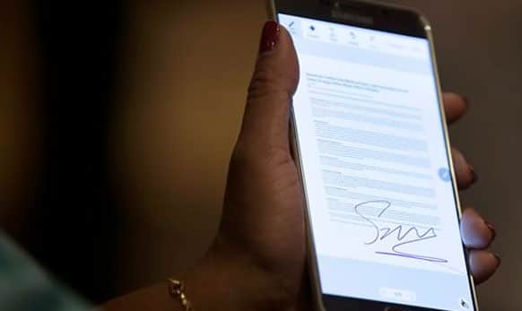 A Samsung employee demonstrates how to sign a document using the new Samsung Galaxy Note 5 in New York. 