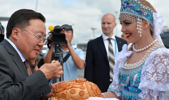 Mongolian President Tsakhiagiin Elbegdorj tests a national salt and bread upon his arrival in Ufa, Russia.