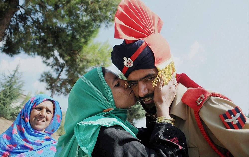 A recruit is greeted by a family members after a passing out parade at a police training centre in Manigam in Ganderbal.
