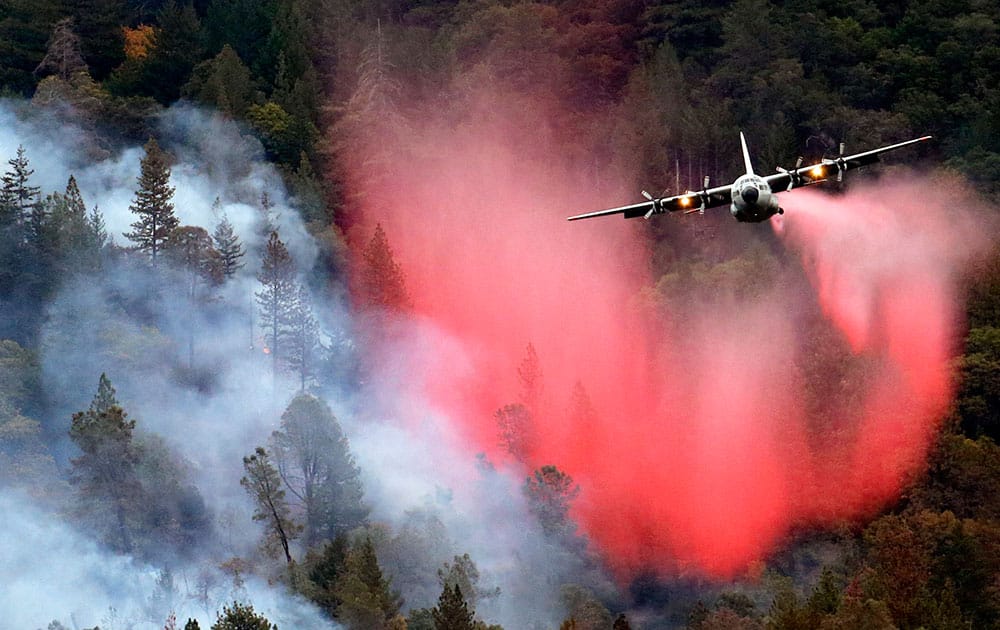 A firefighting plane drops a load of fire retardant over a smoldering hillside in Middletown, Calif. 
