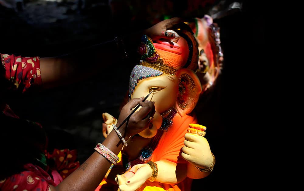 A artist gives final touches to an idol of Hindu god Ganesha in New Delhi.