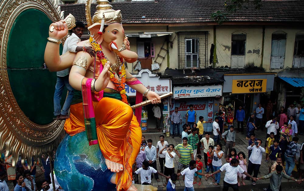 People watch as devotees transport an idol of Hindu god Ganesha from a workshop to a worship venue ahead of the Ganesh Chaturthi festival in Mumbai.