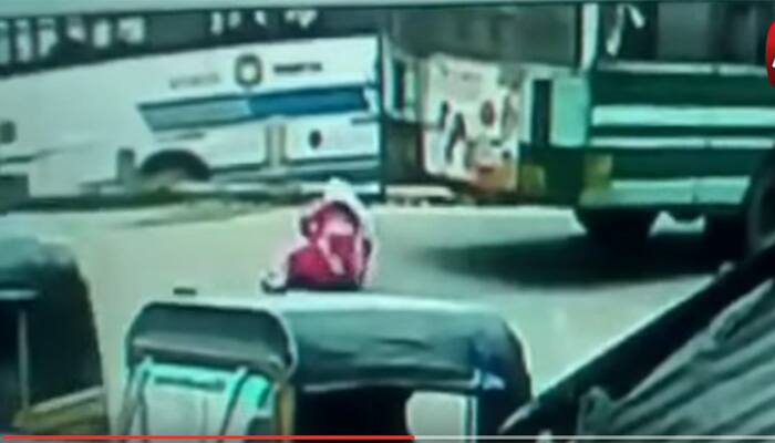 Watch: Woman falls underneath moving bus, narrowly escapes death