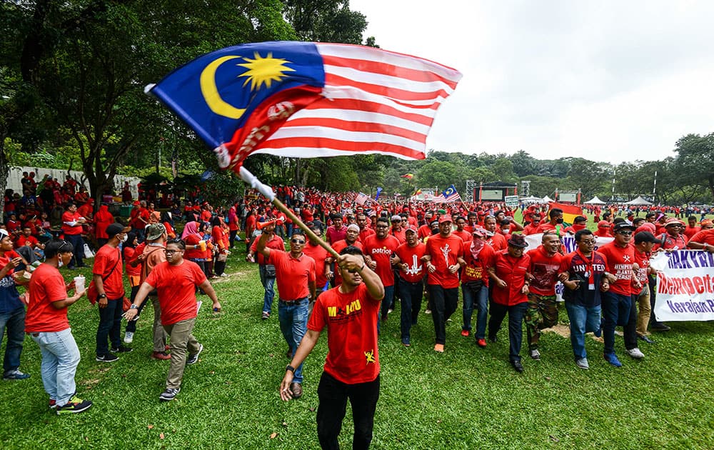 A pro-government 'red shirt' protestor waves the national flag during a rally in Kuala Lumpur, Malaysia.