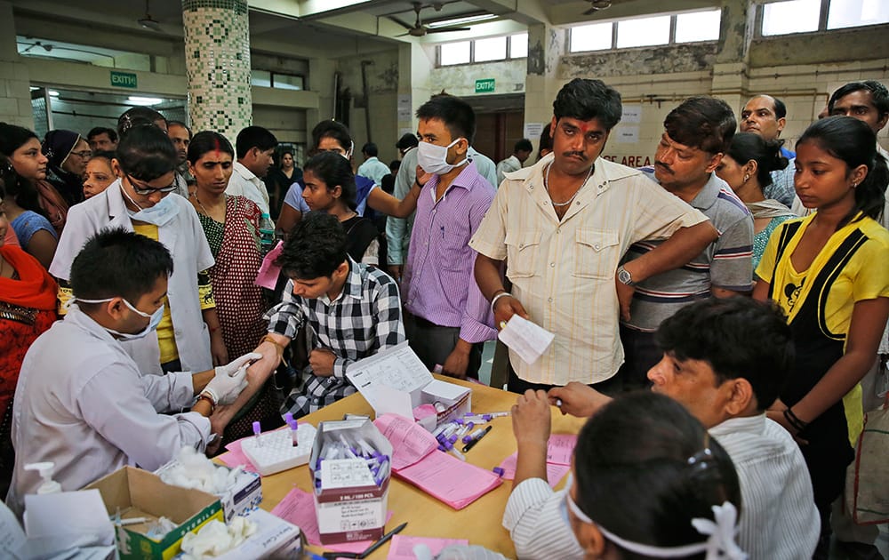 People suffering from fever get their blood test for dengue at a fever clinic run by a government hospital in New Delhi.