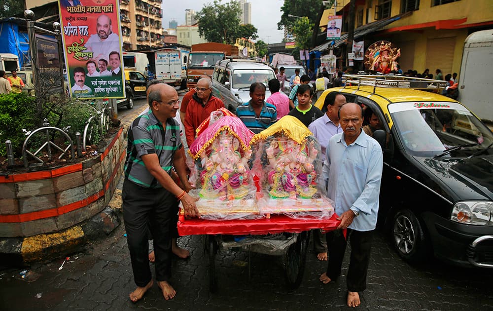 Devotees carry idols of elephant-headed Hindu god Ganesha on a handcart during Ganesha Chaturthi festival in Mumbai.