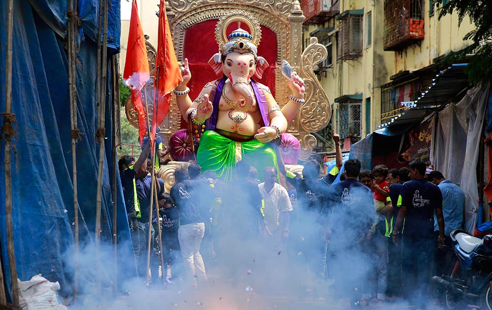 People light firecrackers near a huge idol of elephant headed Hindu god Ganesha during the Ganesh Chaturthi festival in Mumbai.