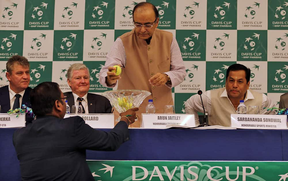 Finance Minister Arun Jaitley, picks up a ball with the name of a player during the draw ceremony of the Davis Cup tennis in New Delhi, India.