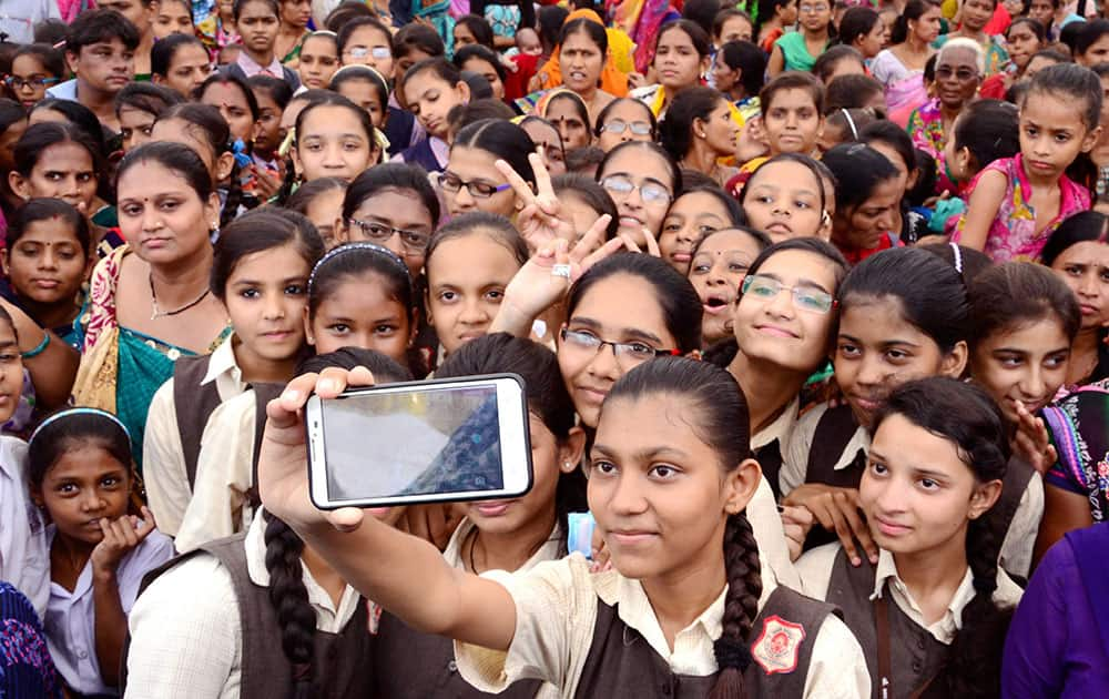 School girls in Ahmedabad take a selfie during a function to save and educate the girl child.