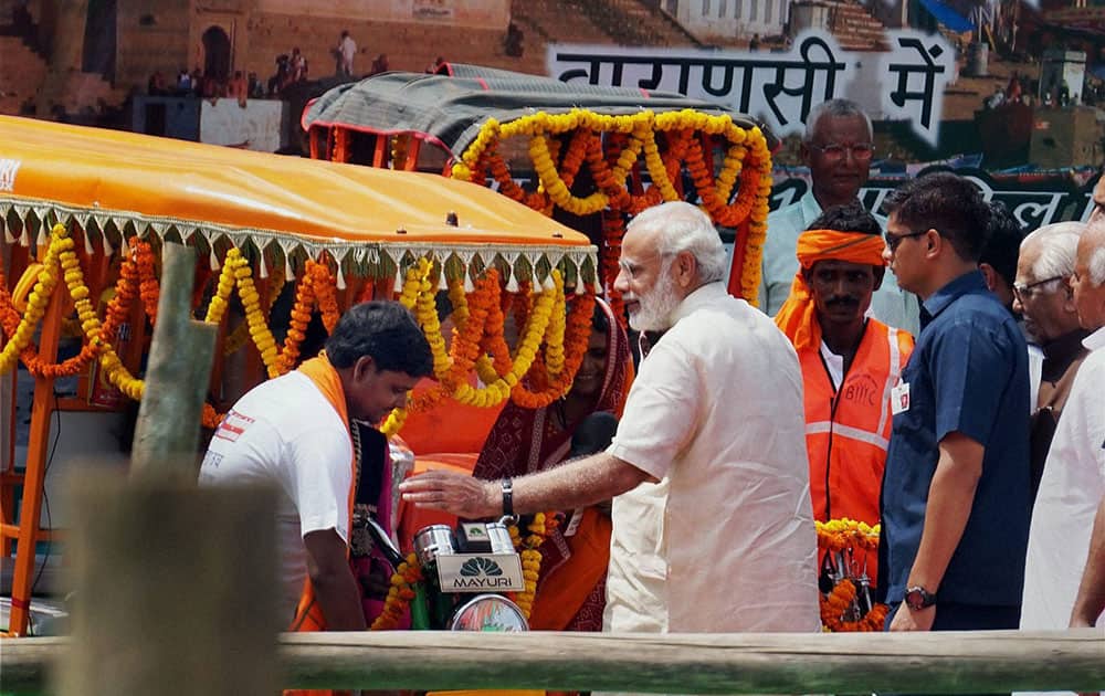 Prime Minister Narendra Modi giving away e-rickshaws and pedal rickshaws to help impoverished families with sustainable livelihood under the government’s financial inclusion programme, at a function in his constituency Varanasi.