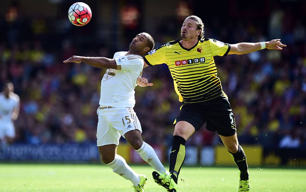 Watford's Sebastien Prodl, right, and Swansea City's Wayne Routledge battle for the ball during their English Premier League soccer match at Vicarage Road, London.