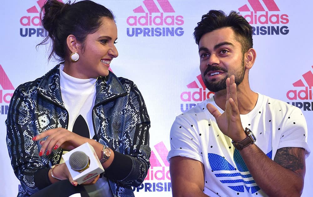Indian Cricketer Virat Kohli with Tennis Star Sania Mirza shares a moment during the launch of a sports wear showroom in Bengaluru.
