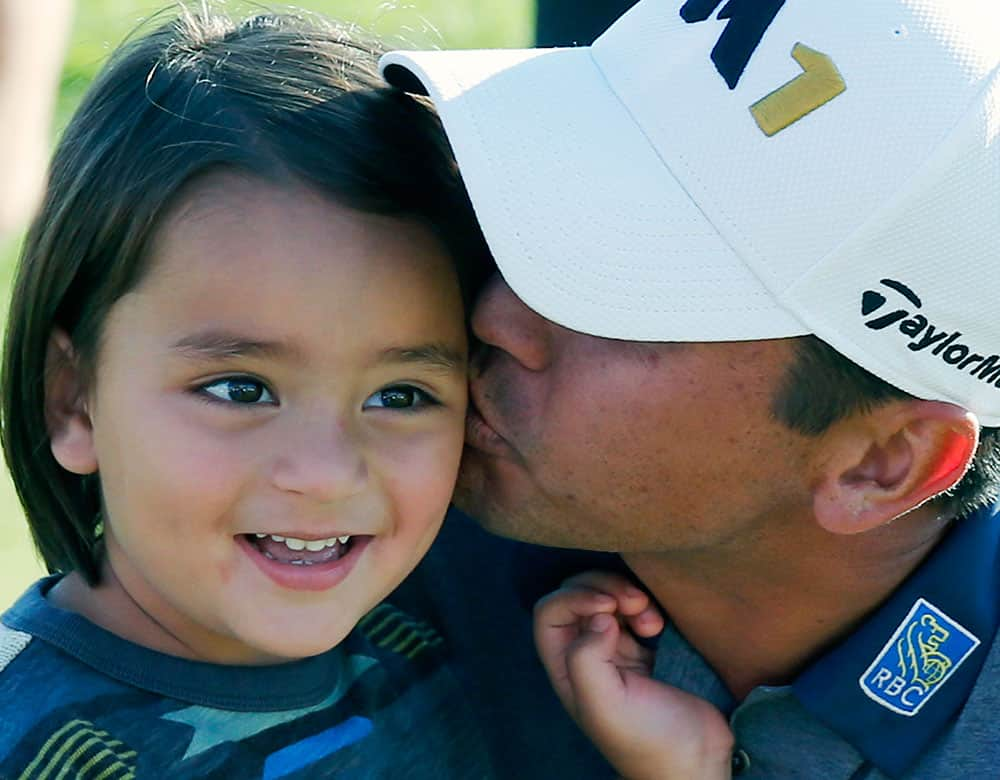 Jason Day of Australia, kisses his son Dash, after winning the BMW Championship golf tournament at Conway Farms Golf Club in Lake Forest, Ill. 