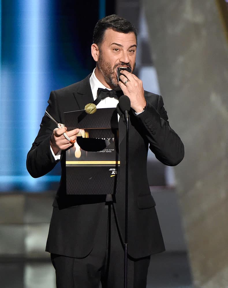 Jimmy Kimmel eats the ballot result as he presents the award for outstanding lead actor in a comedy series at the 67th Primetime Emmy Awards.