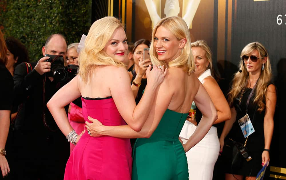 Elisabeth Moss, left, and January Jones arrive at the 67th Primetime Emmy Awards.