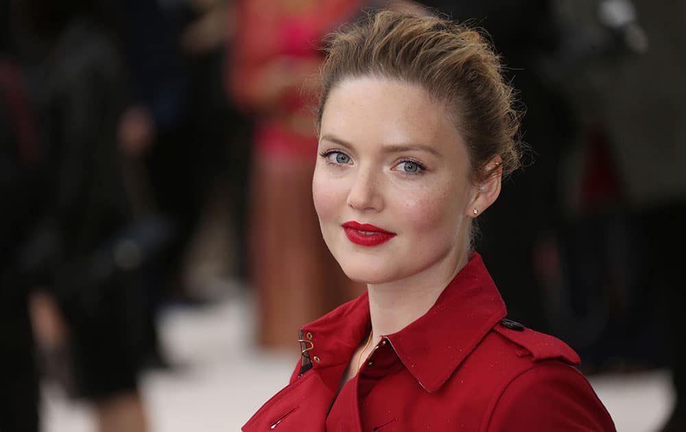 Actress Holliday Grainger poses for photographs as she arrives for the Burberry Prorsum Womenswear Spring and Summer show in London.