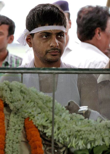 Abhishek Dalmiya, son of Jagmohan Dalmiya, Board of Control for Cricket in India (BCCI) president and former International Cricket Council chief, stands next to the glass casket carrying his fathers body during his funeral in Kolkata.