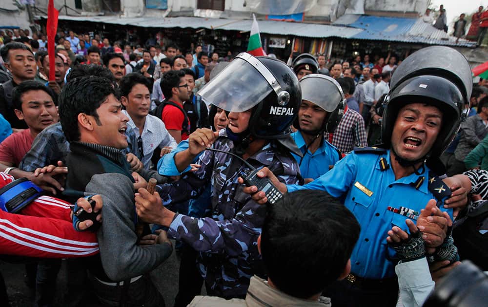 Nepalese protesters try to clash with policemen after burning a copy of the new constitution during the protest organized by splinter of the Maoist party, alliance of ethnic group and Madhesi party, in Kathmandu, Nepal.
