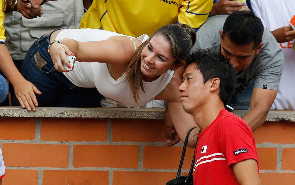 Kei Nishikori of Japan poses for a selfie with a fan during the Davis Cup World Group play-offs in Pereira, Colombia.
