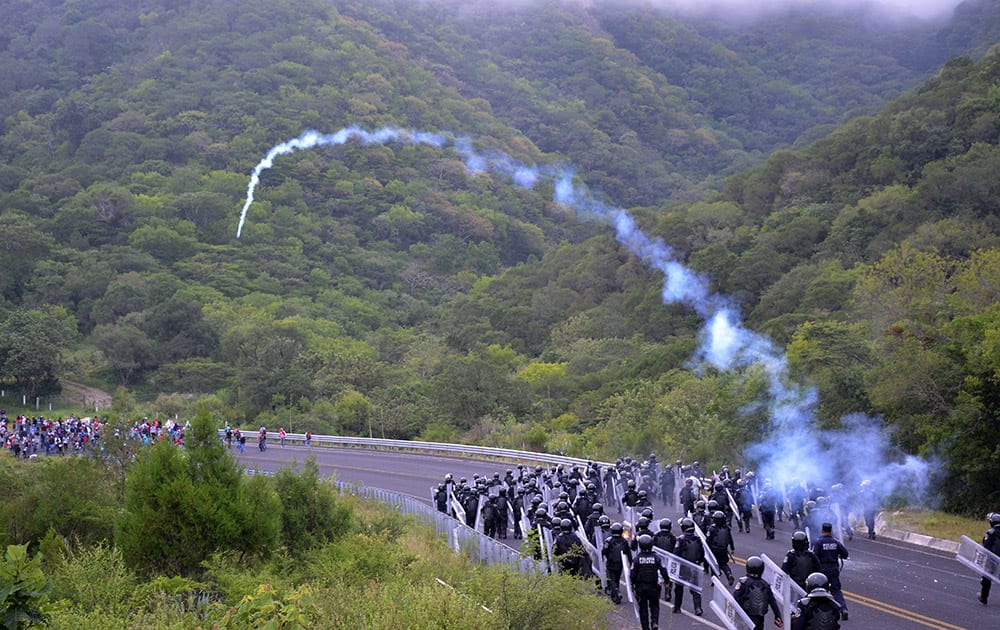 Police in riot gear fire tear gas toward students armed with rocks, sticks, and firecrackers, as police block the students from the Rural Normal School of Ayotzinapa from reaching the city of Chilpancingo, in Mexico's southern Guerrero state, to protest.