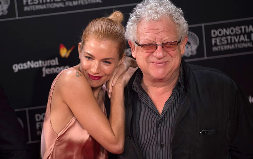 British actress Sienna Miller, poses for photographers beside film director, Jeremy Thomas, on arrival at the Kurssal cinema to promote the film, ''High Rise'', during the 63rd San Sebastian Film Festival.