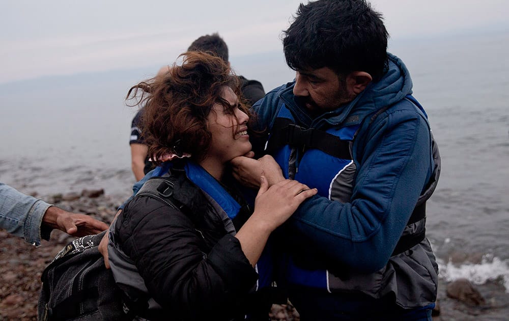 A man checks on his wife as they arrive with other migrants on the shores of the Greek island of Lesbos after crossing the Aegean Sea from Turkey on a inflatable dinghy.