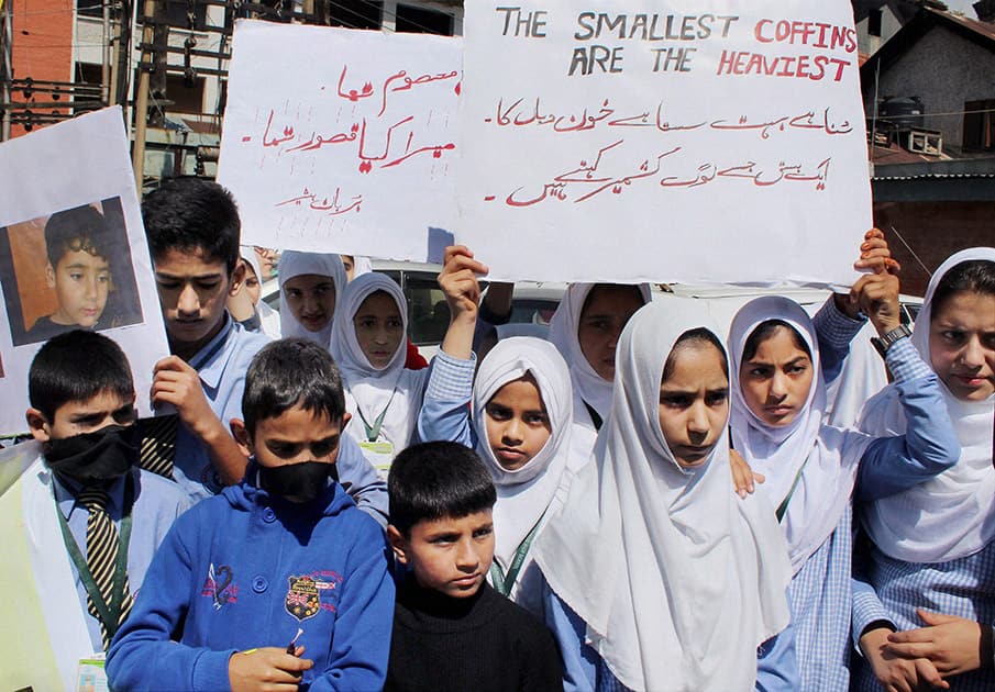 School students hold placards during a protest against the killing of a three year old boy by militants, at Lal Chowk in Srinagar.