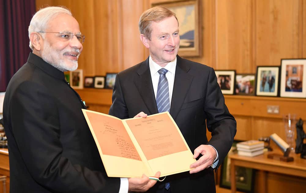 Prime Minister Narendra Modi presenting a document to his Irish counterpart Enda Kenny at a meeting in Dublin.
