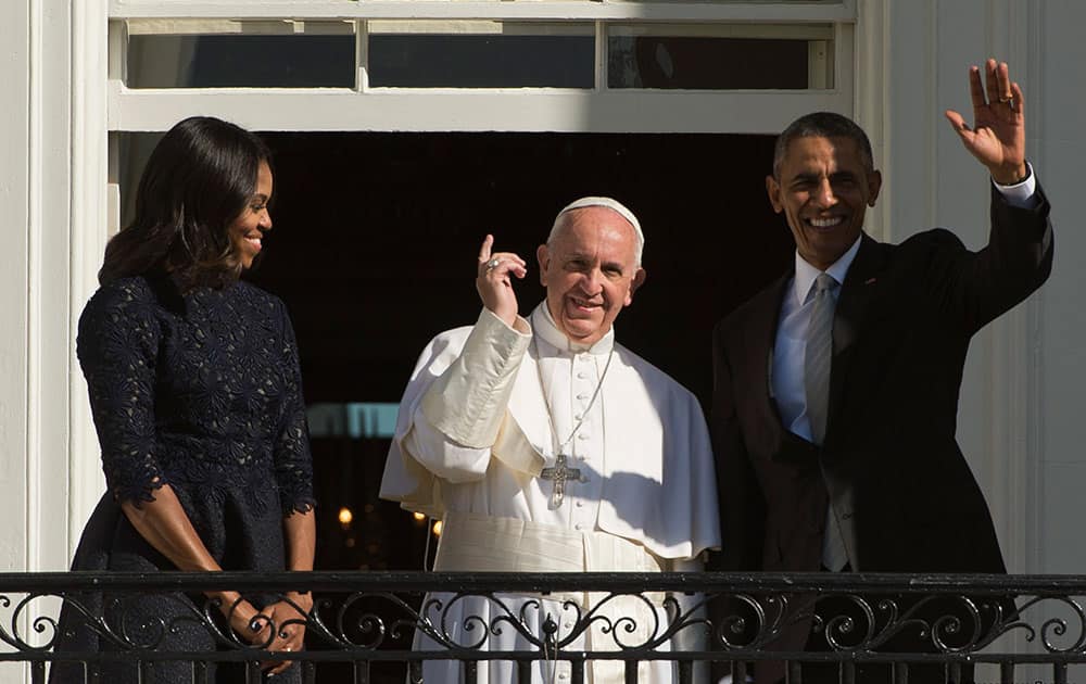 President Barack Obama, first lady Michelle Obama and Pope Francis wave to the crowd on the South Lawn of the White House in Washington. 