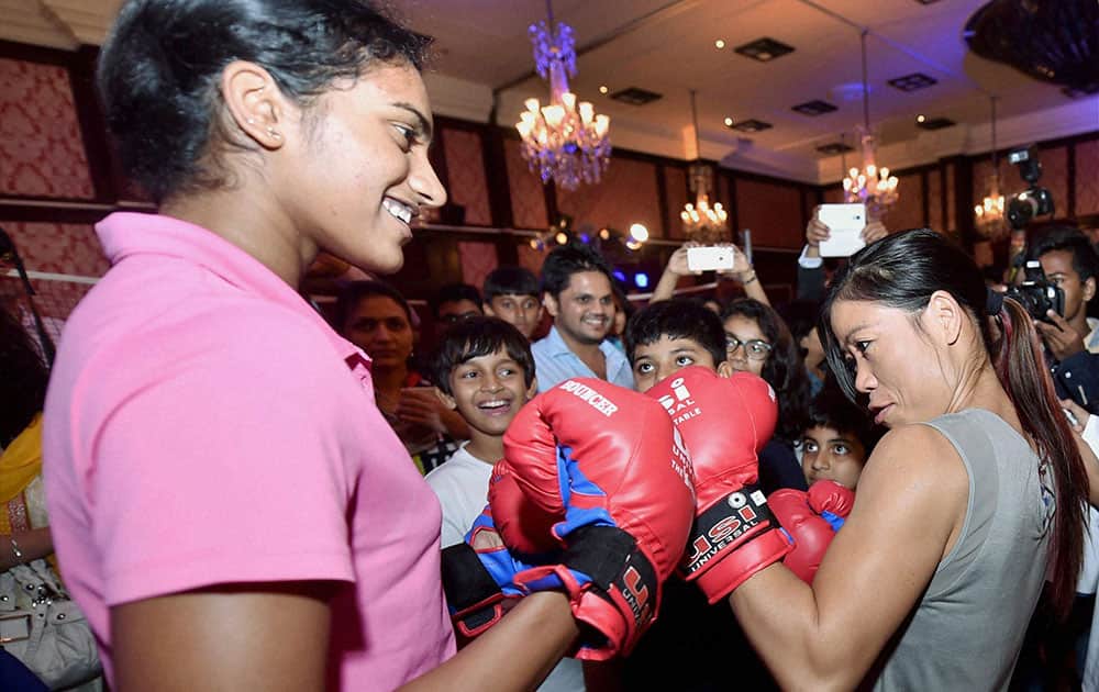Boxing star Mary Kom (R) and badminton player PV Sindhu during the fund raising event in Mumbai.