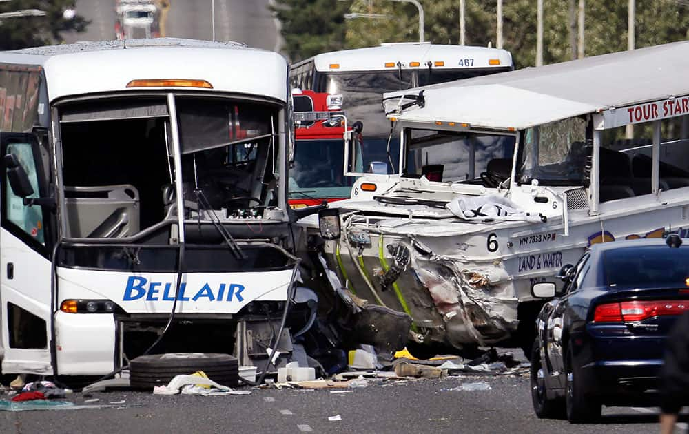 A charter bus, left, and an amphibious tour vehicle remain on the Aurora Bridge after colliding in a deadly crash involving several vehicles in Seattle.