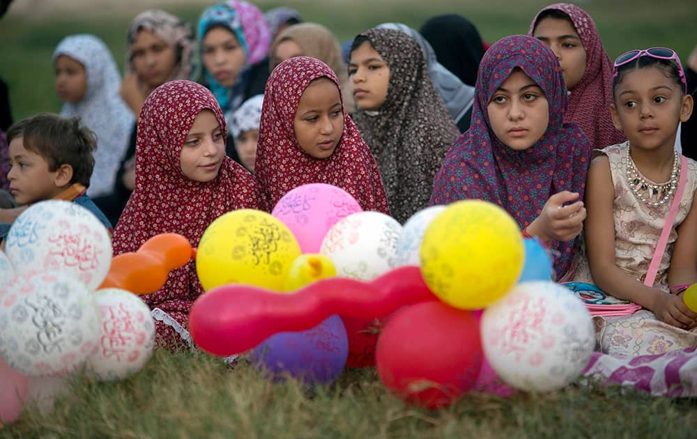 Palestinian girls wearing hijabs take part in the Eid al-Adha prayer in a public garden in Gaza City.