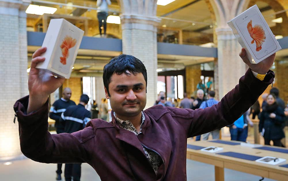 Sam Shaikh holds up two new iPhones after the release and sale start of the new Apple IPhone 6S at the Apple store in Covent Garden, London.