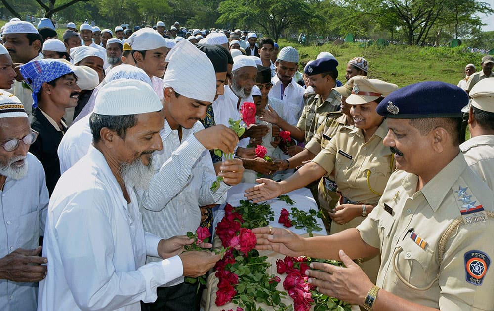 Police officers giving roses to Muslims while greeting them on the occasion of Eid-al-Adha in Karad.